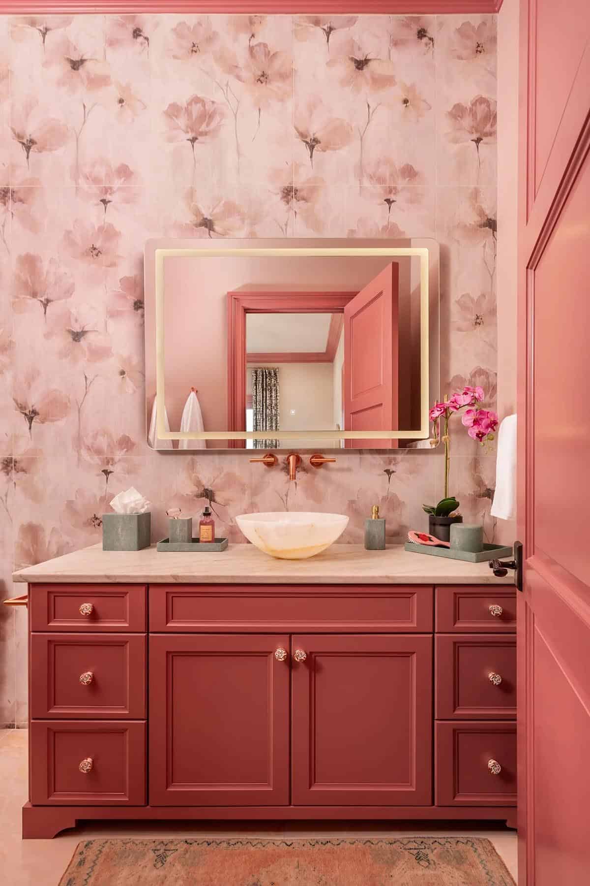 Pink floral tile bathroom with crimson vanity, onyx vessel sink, and backlit mirror
