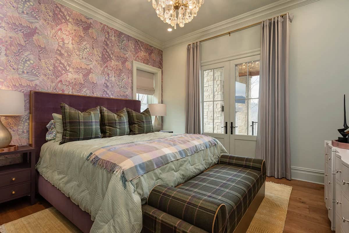 Guest bedroom with butterfly wallpaper, plum velvet headboard, and plaid bench