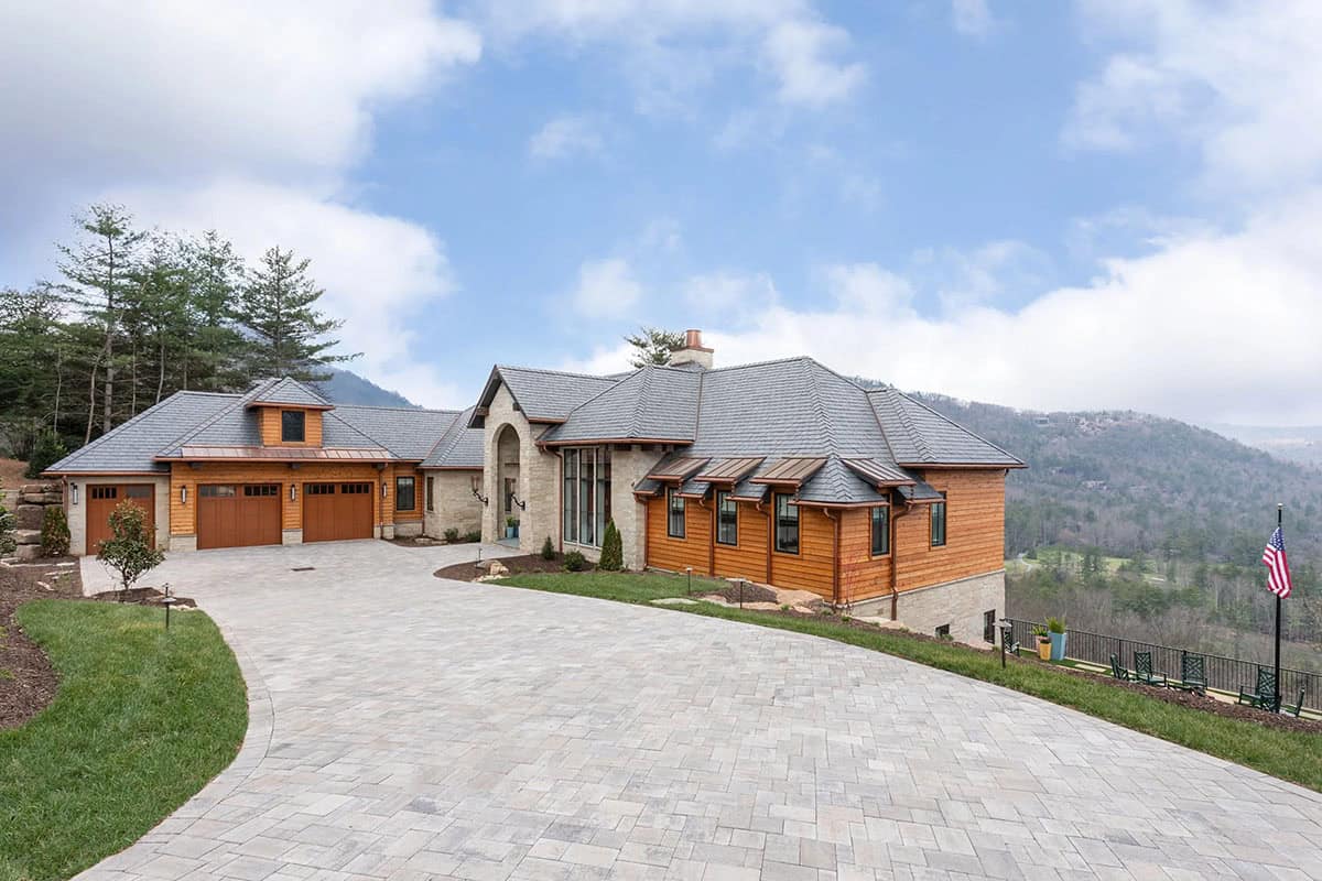 Mountain home exterior side view with cedar siding, stone accents, slate roof, and Blue Ridge mountain backdrop