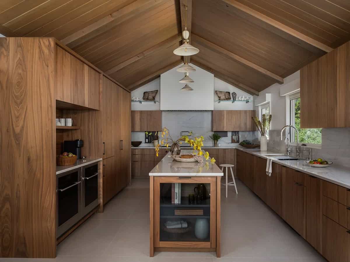 Walnut kitchen with vaulted ceiling, marble island and stacked pendant lights