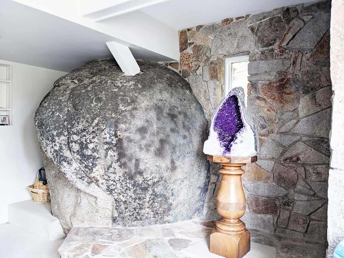 Mountain lodge home lower-level lounge with large granite boulder before the remodel