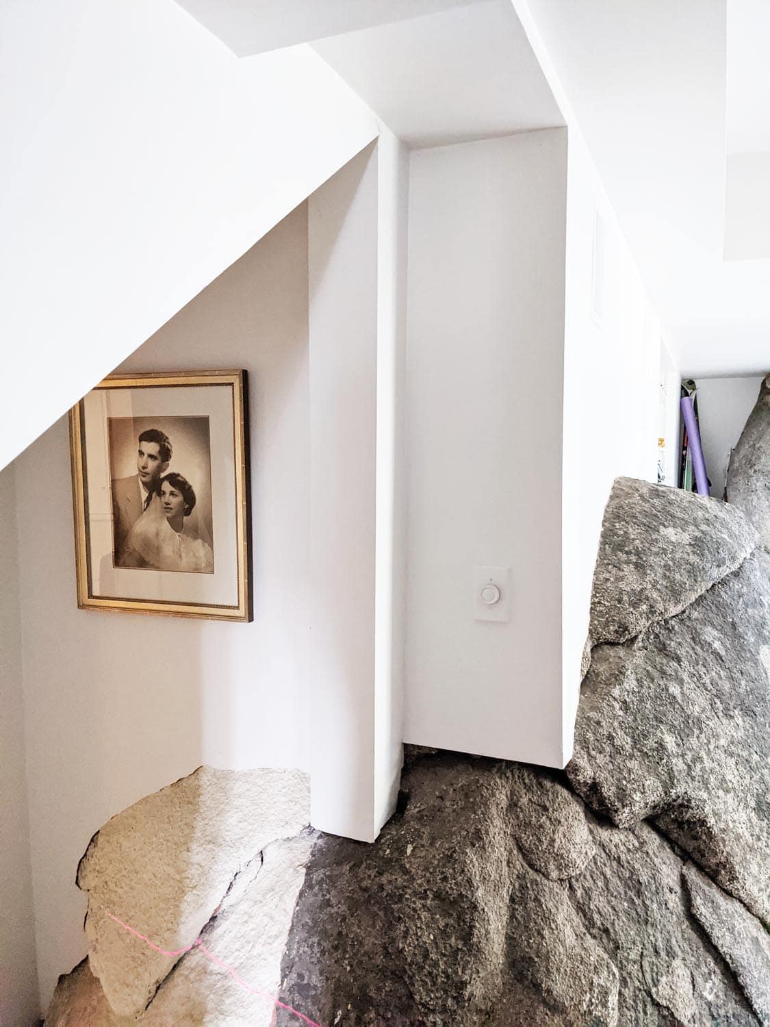 Mountain lodge home lower-level lounge with large granite boulder before the remodel