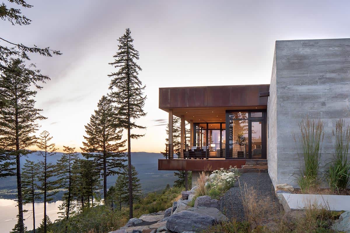 Cantilevered deck with Corten steel and wood ceiling overlooking Montana lake at sunset