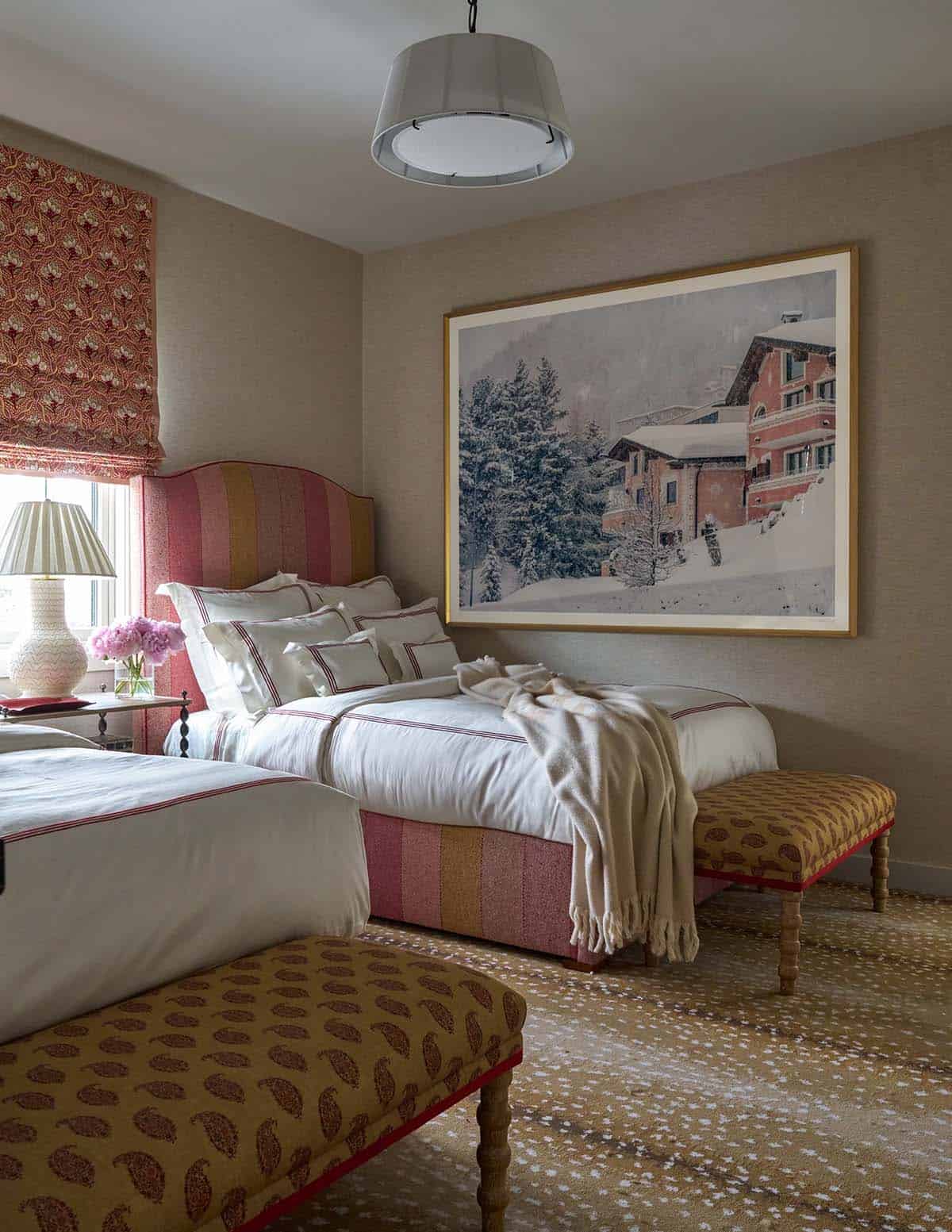 Twin bedroom with striped upholstered headboards, alpine chalet artwork, paisley benches, and patterned roman shades