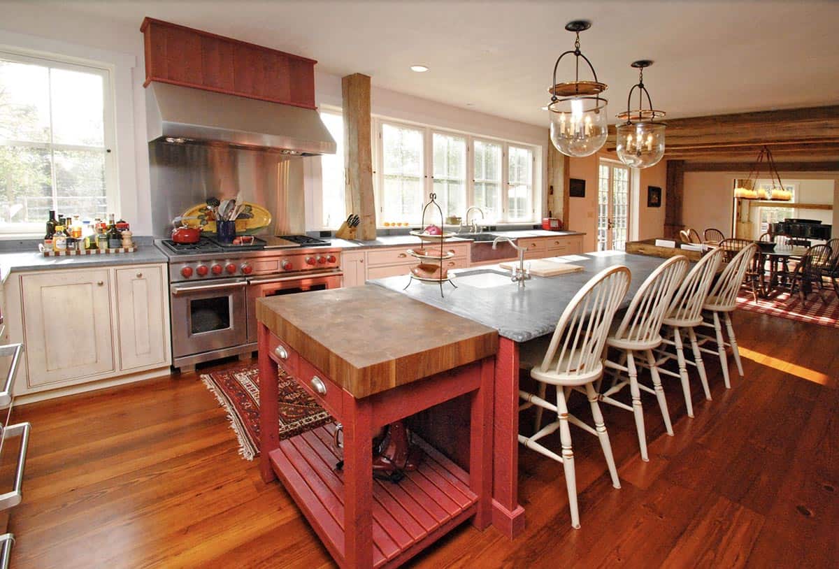 Farmhouse kitchen with red island, butcher block top, soapstone counters, and stainless range
