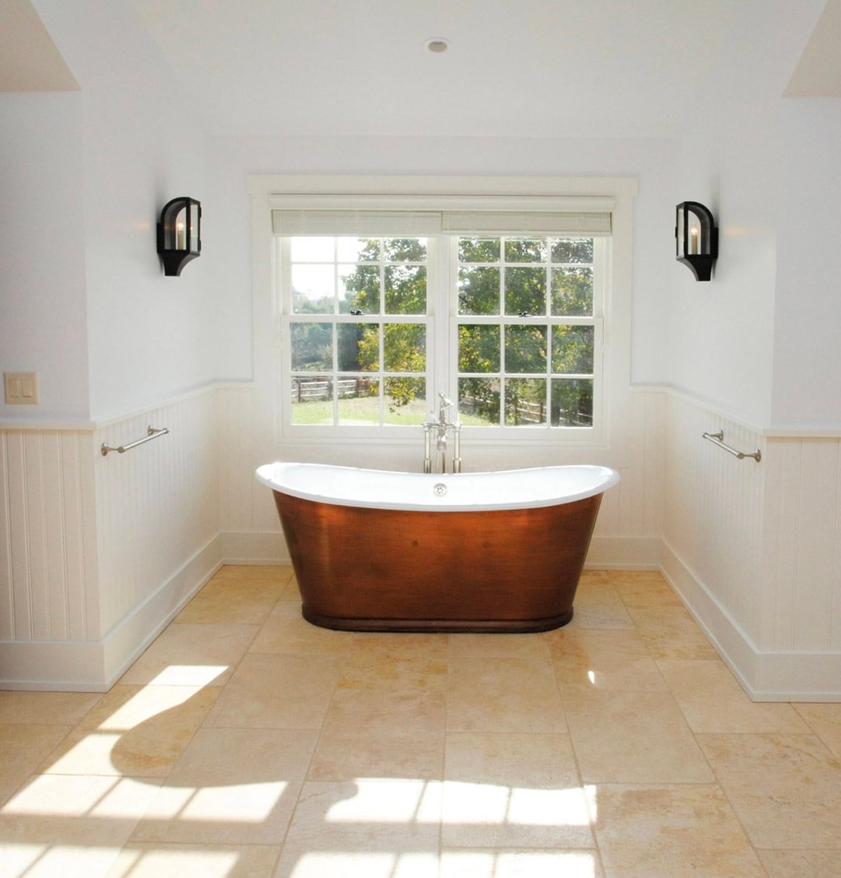 Bright white bathroom with freestanding copper soaking tub and garden view window