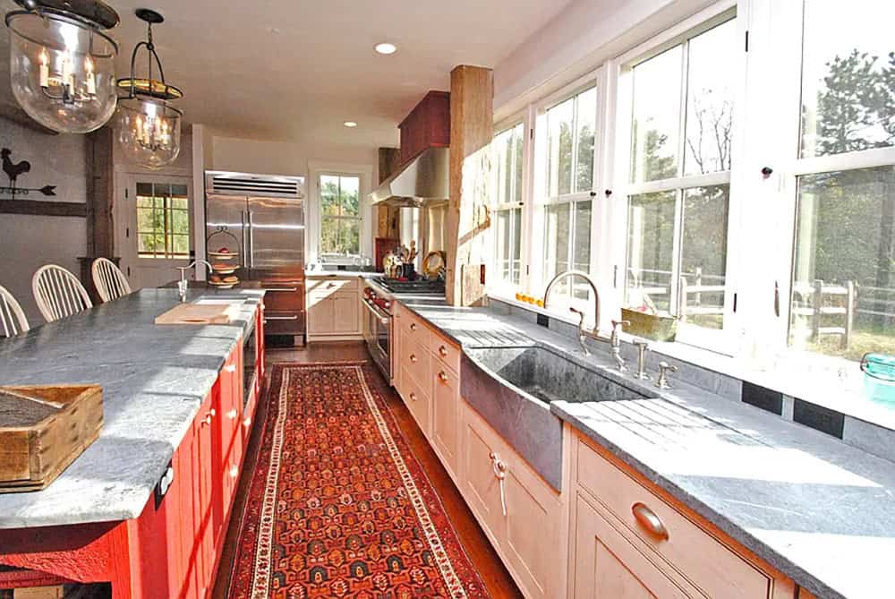 Farmhouse kitchen with soapstone farmhouse sink, red island, and glass globe pendant lights