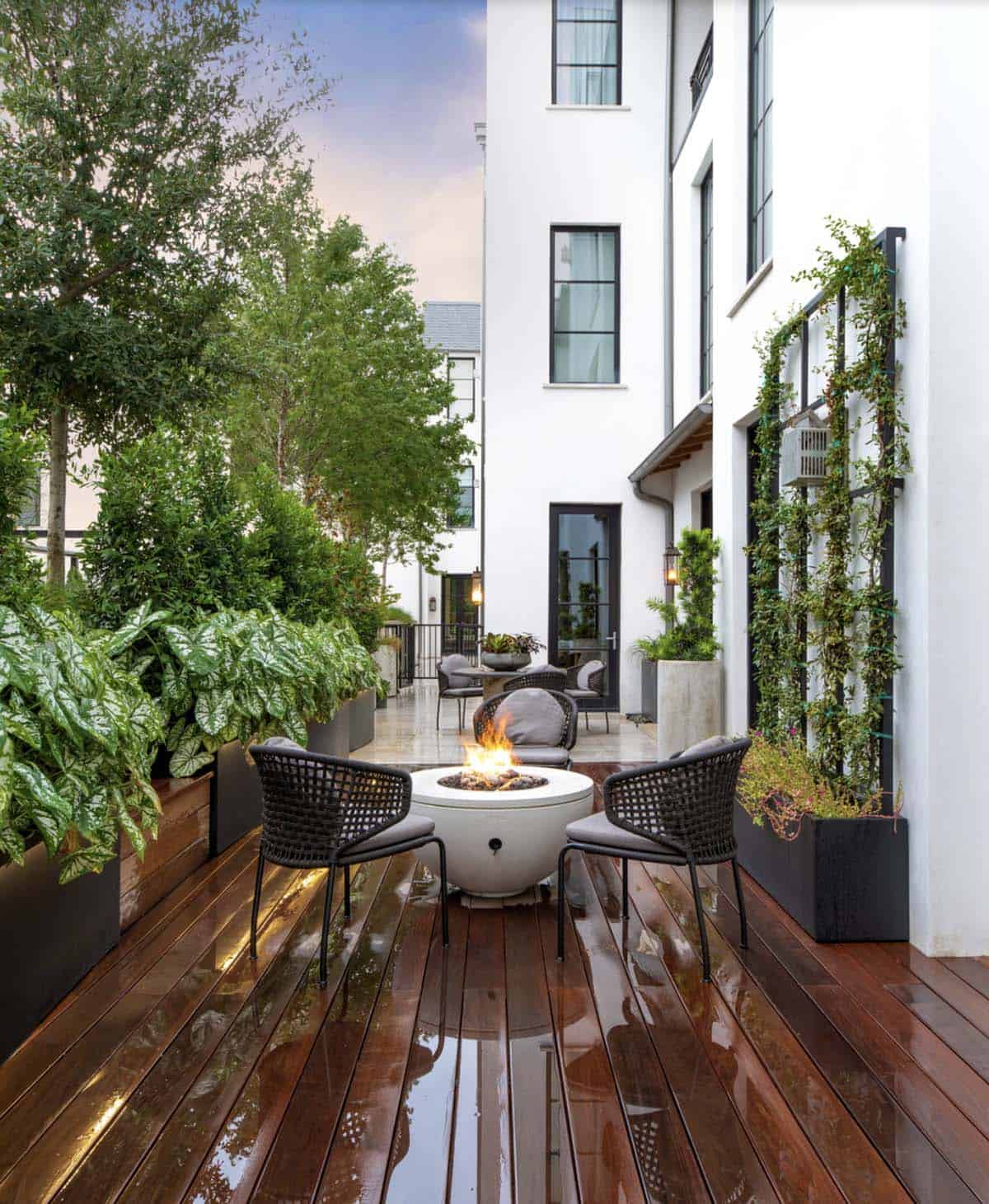 Alt tag: Small urban backyard with raised planter privacy screens fire pit and wood deck