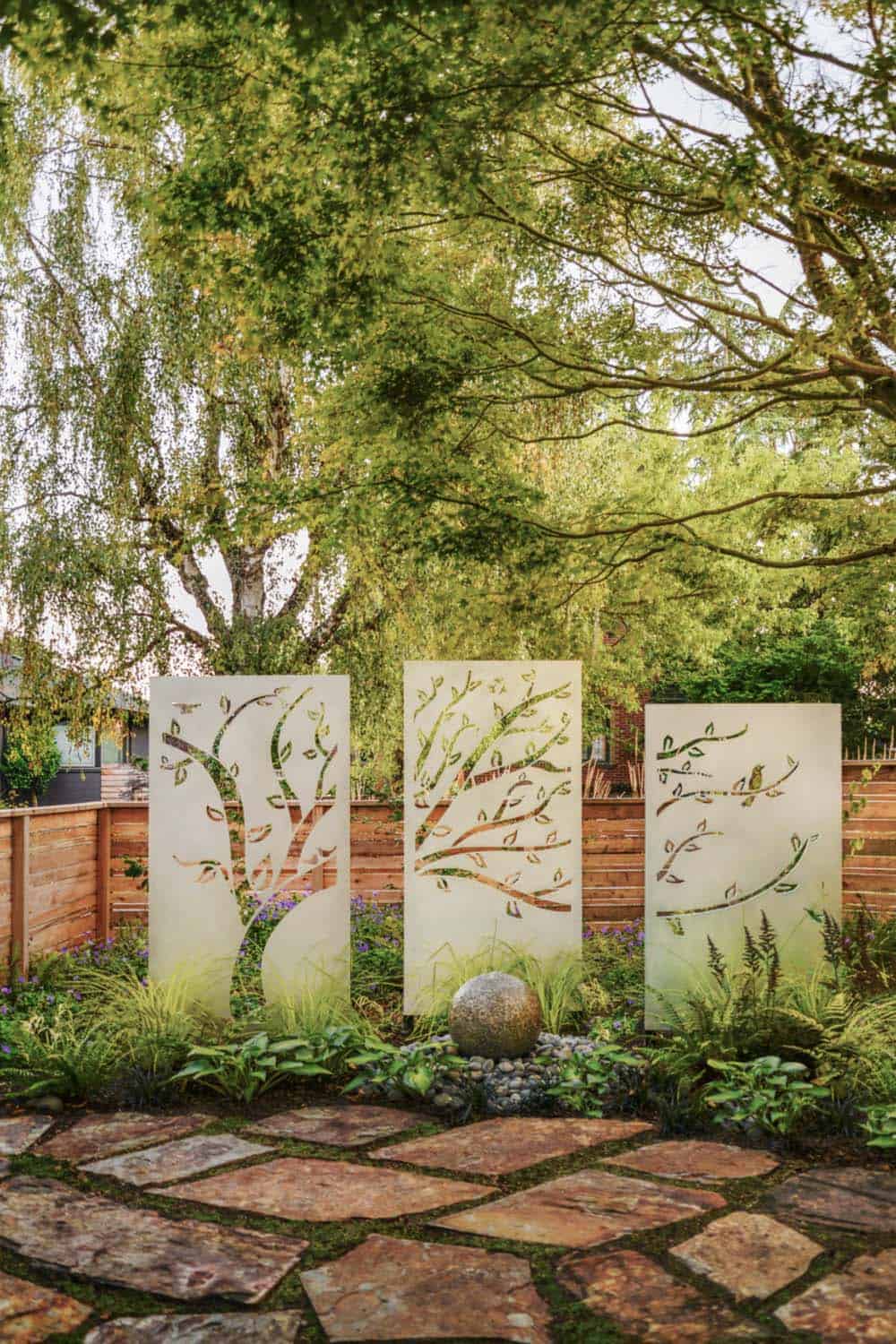 Decorative laser cut aluminum privacy screen panels in a garden