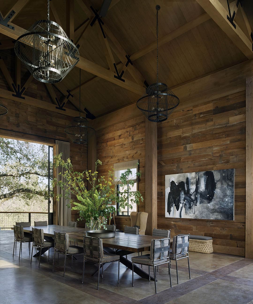 Soaring barn dining room with reclaimed wood walls, wire pendant lights and abstract art