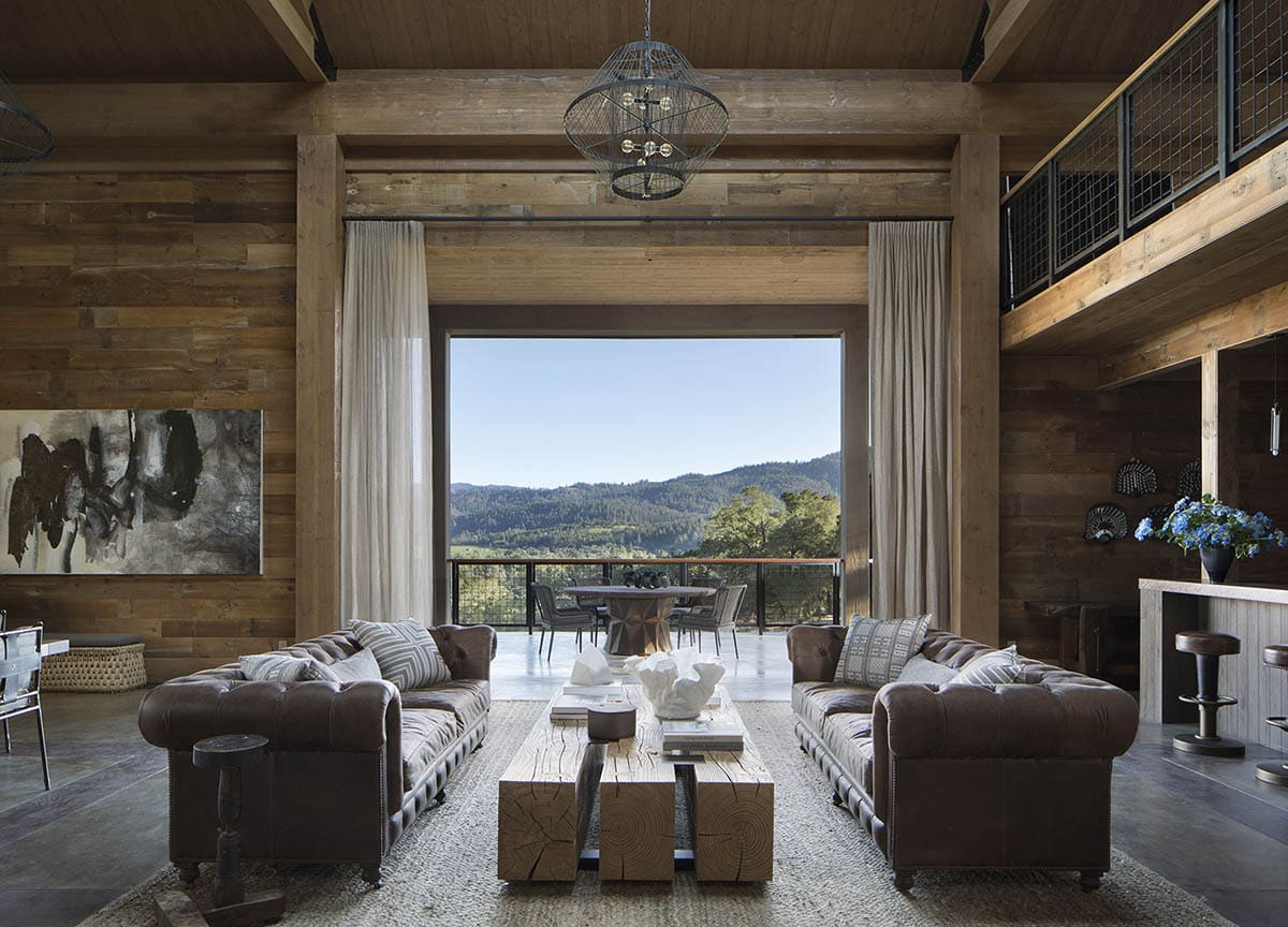 Barn living room with leather Chesterfield sofas and panoramic Napa Valley vineyard views
