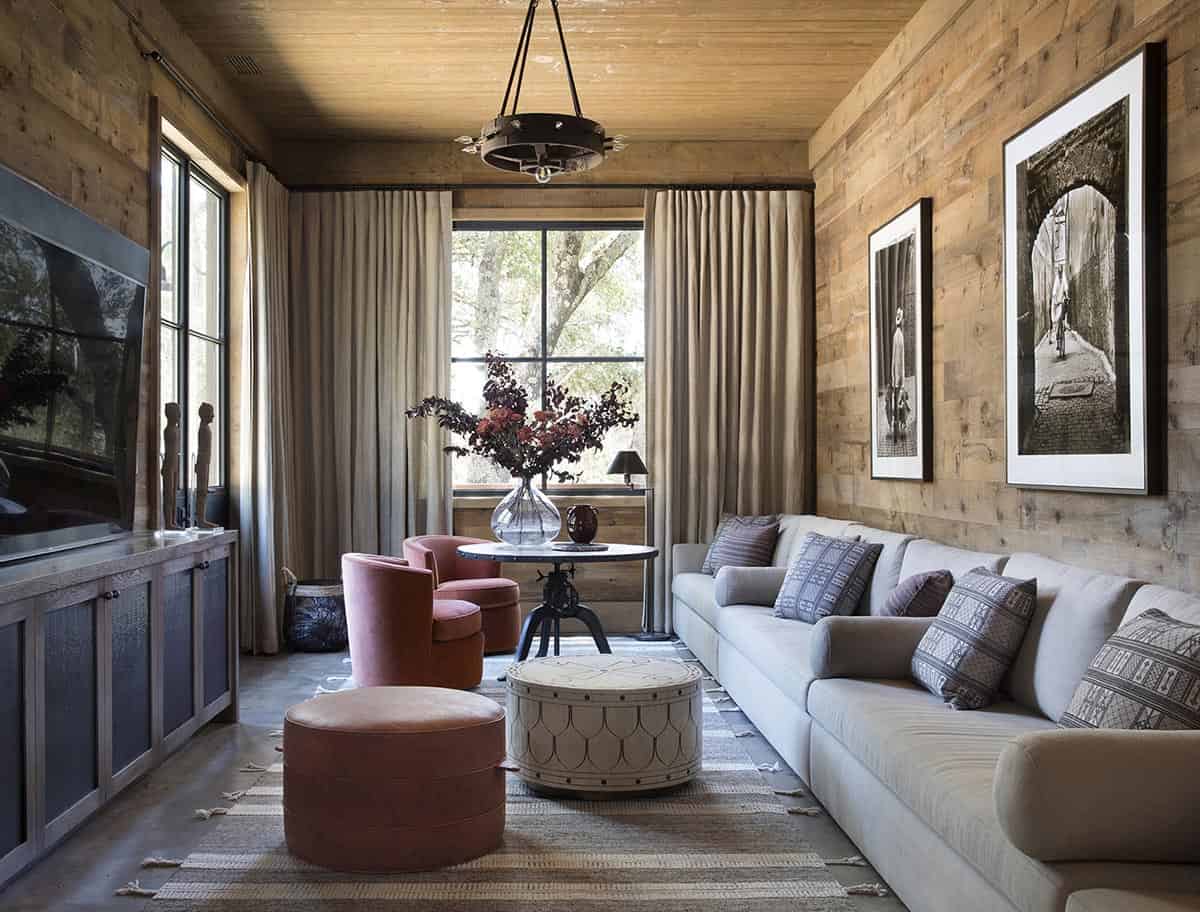 Cozy media room with velvet swivel chairs, gray sofa and reclaimed wood walls