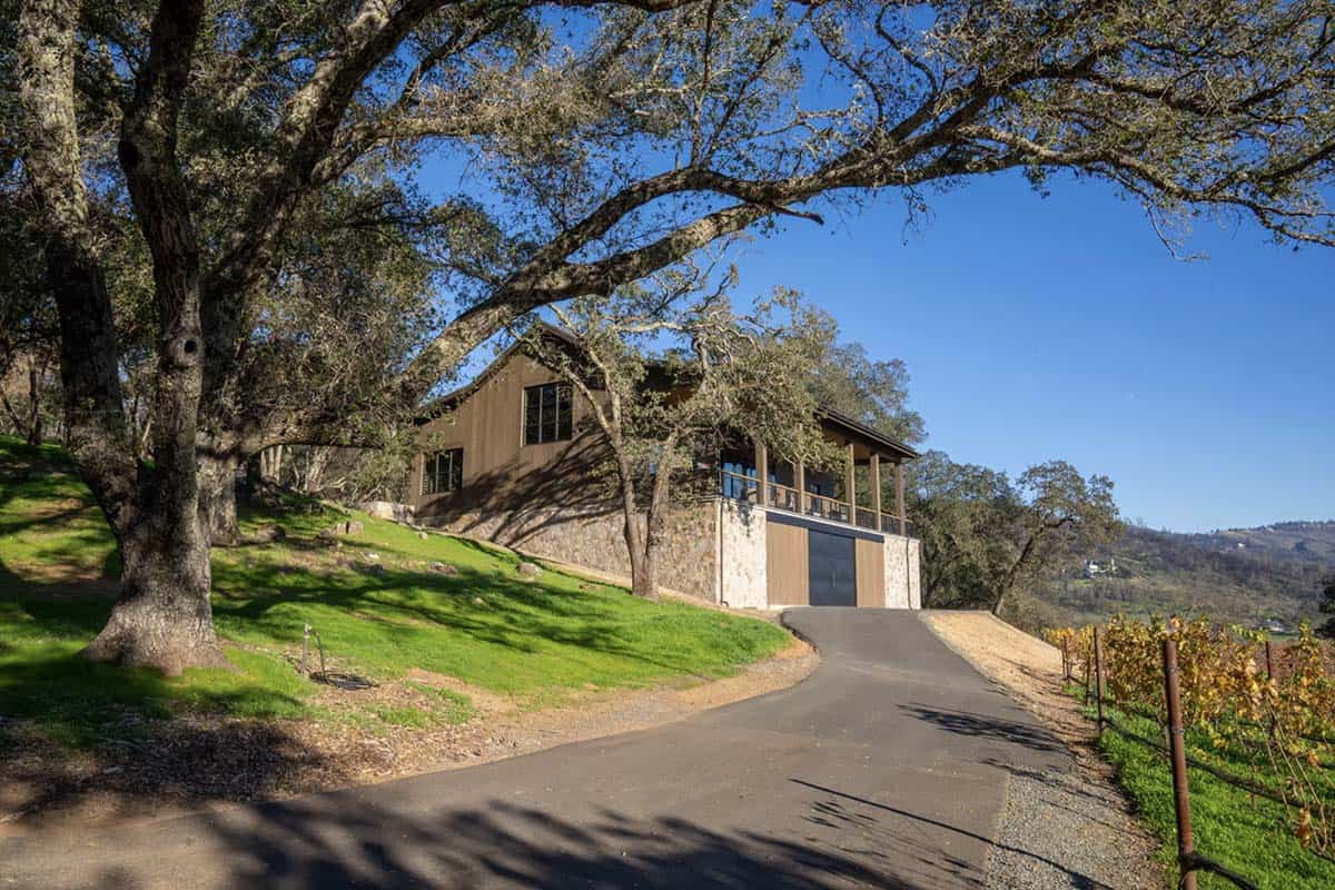 Barn exterior nestled among oak trees on a Napa Valley hillside with vineyard views