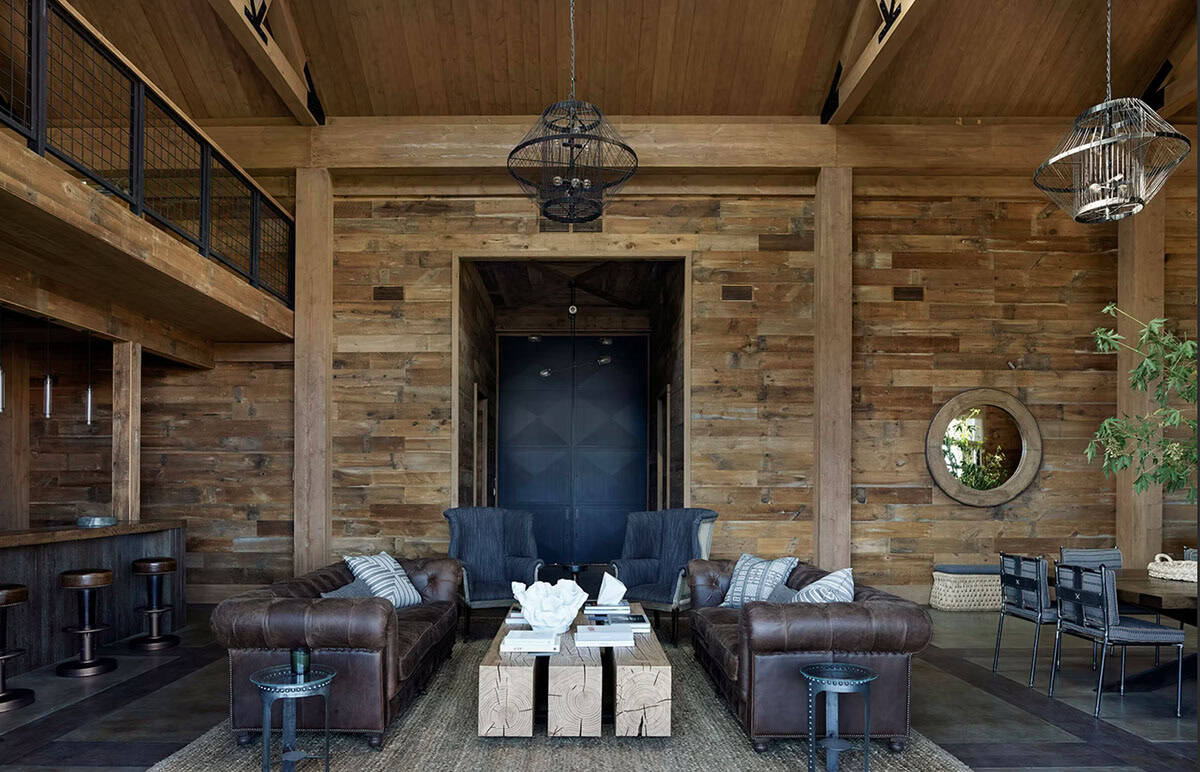 Open plan barn interior with leather sofas, wire pendants and reclaimed wood throughout