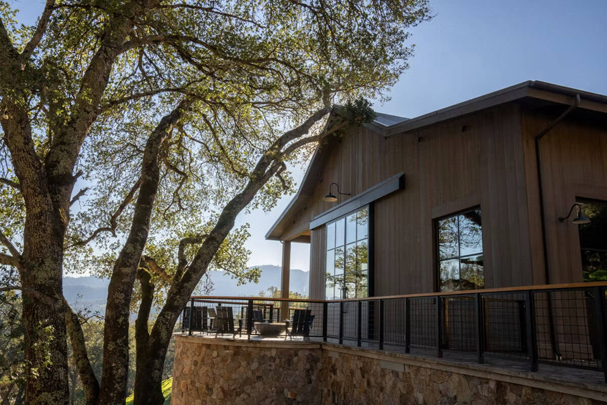 Barn exterior deck with mountain views framed by oak trees at golden hour