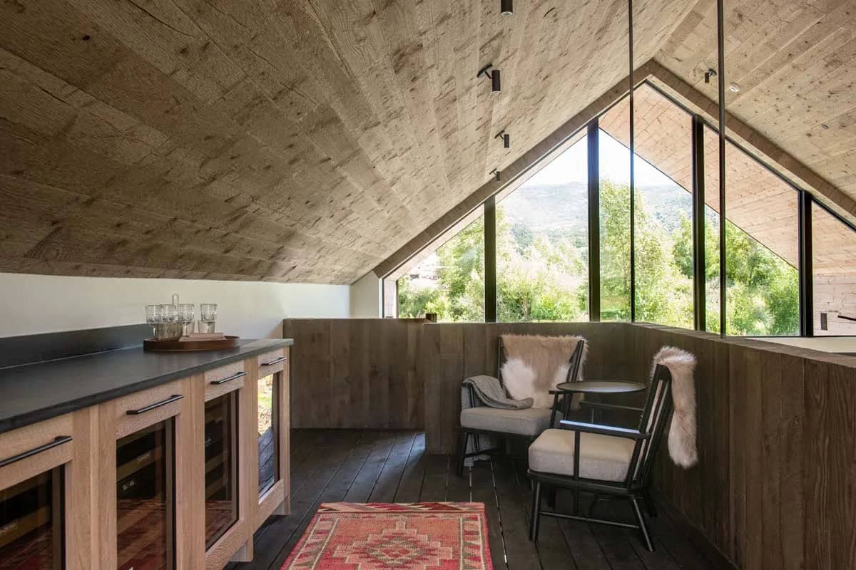Lofted bar and lounge with vaulted wood ceiling, dark countertop, and floor-to-ceiling mountain views, Utah ranch