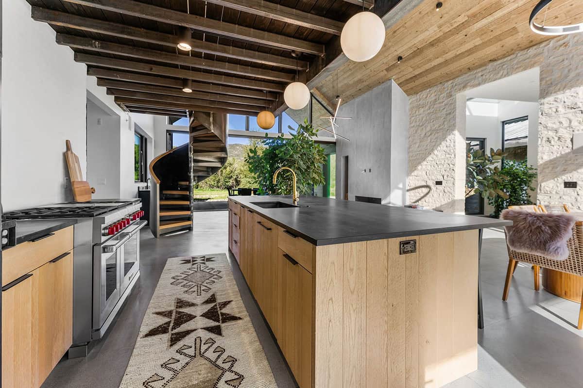 Loft lounge with curved wood ceiling, fur-draped chairs, and panoramic hillside views