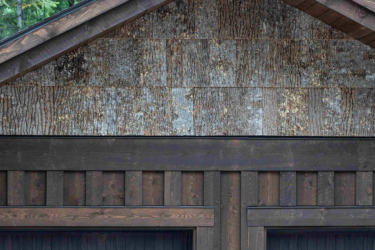 Garage gable detail featuring salvaged poplar bark shingles above dark board-and-batten wood siding