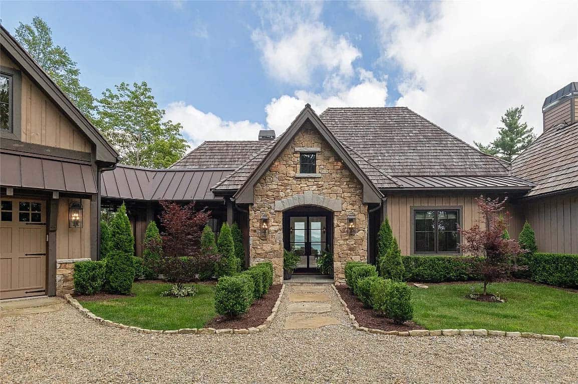 front entry, stone arched portico, black French doors, iron lanterns, boxwood landscaping, cedar shake roof