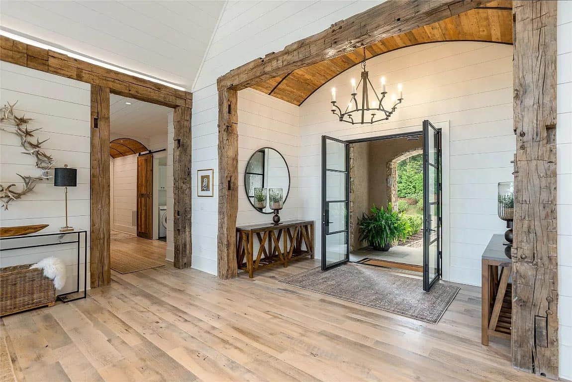 foyer, reclaimed wood beam doorframes, shiplap walls, vaulted wood ceiling, iron chandelier, wide plank hardwood floors
