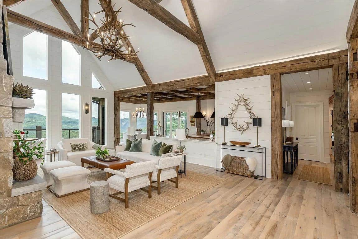 living room, antler chandelier, reclaimed beam trusses, white sectional, green velvet pillows, mountain views