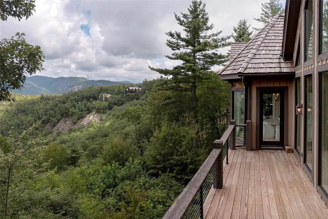 Covered deck of rustic mountain home with cedar shake roof overlooking forested Blue Ridge Mountain canyon