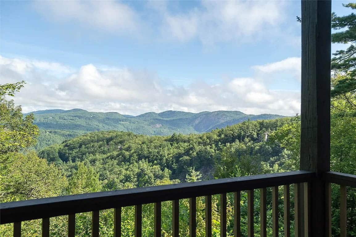 Blue Ridge Mountain panorama with layered green ridgelines and rocky outcroppings viewed from lower level deck railing