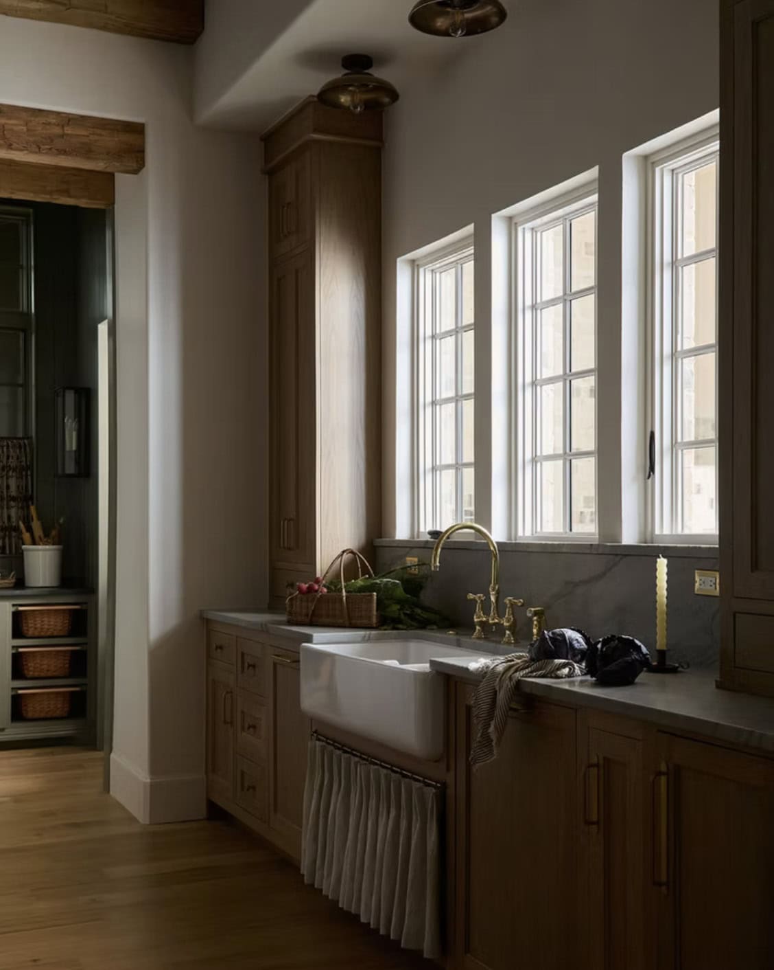 Farmhouse Sink Nook with Brass Fixtures and Skirted Cabinet