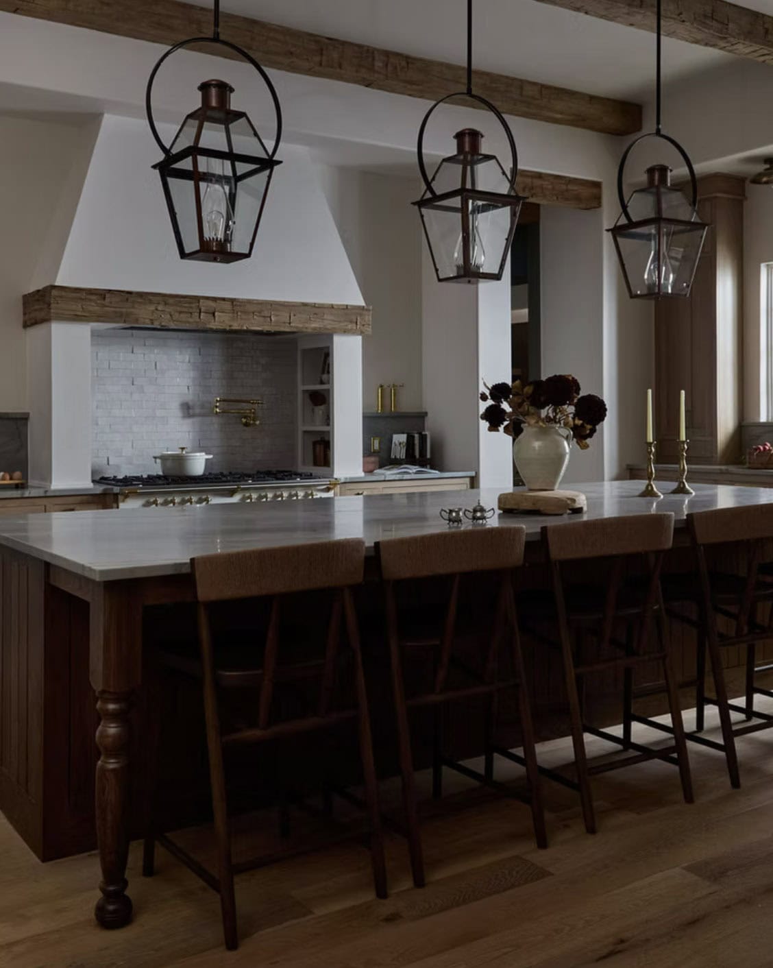 Dark Island Kitchen with Three Lanterns and White Plaster Hood