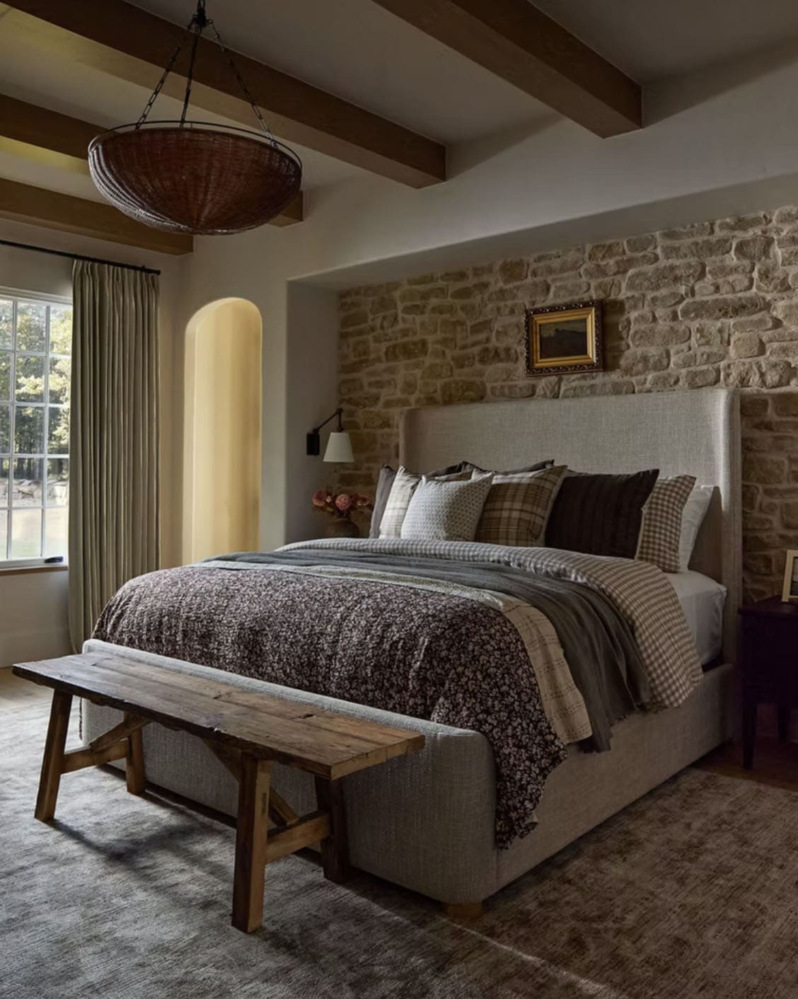 Primary Bedroom with Stone Accent Wall and Wicker Pendant