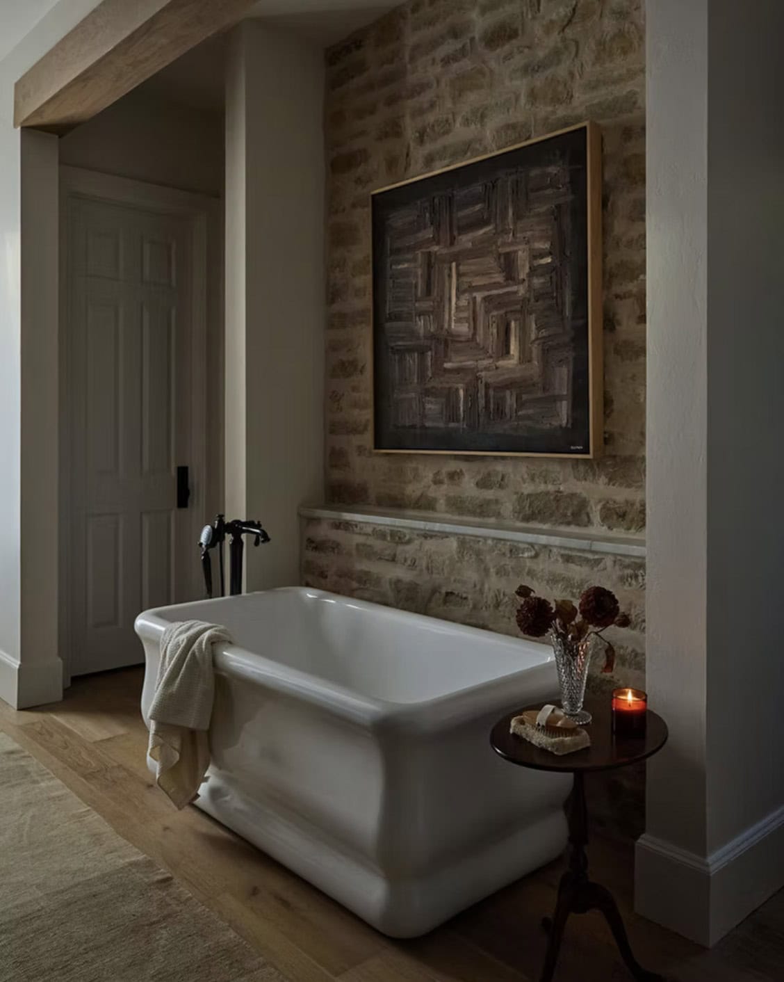 Freestanding Soaking Tub Against Stone Wall with Candle