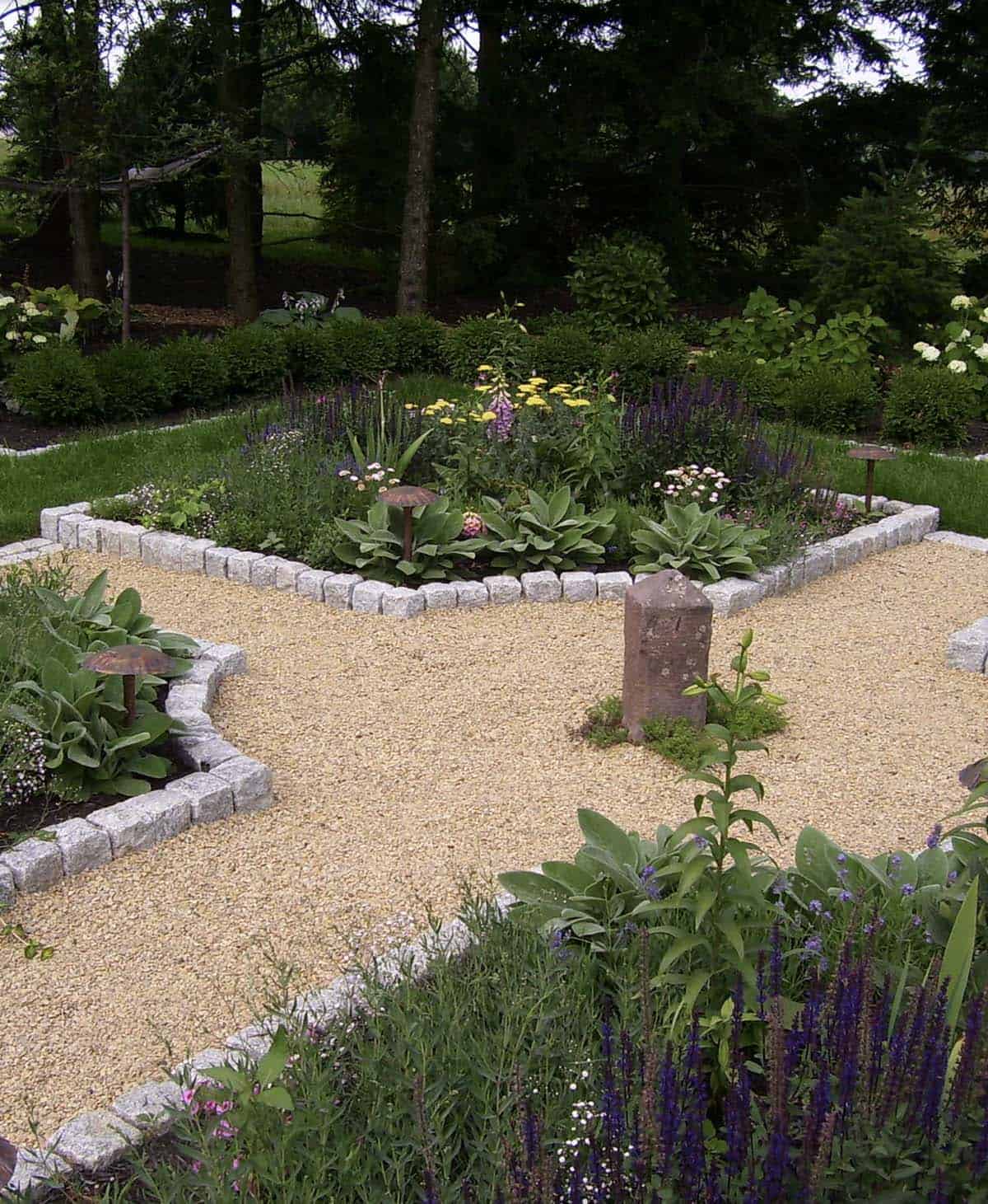 Four-corner backyard garden with cobblestone edging and gravel paths at a modern farmhouse in Pennsylvania