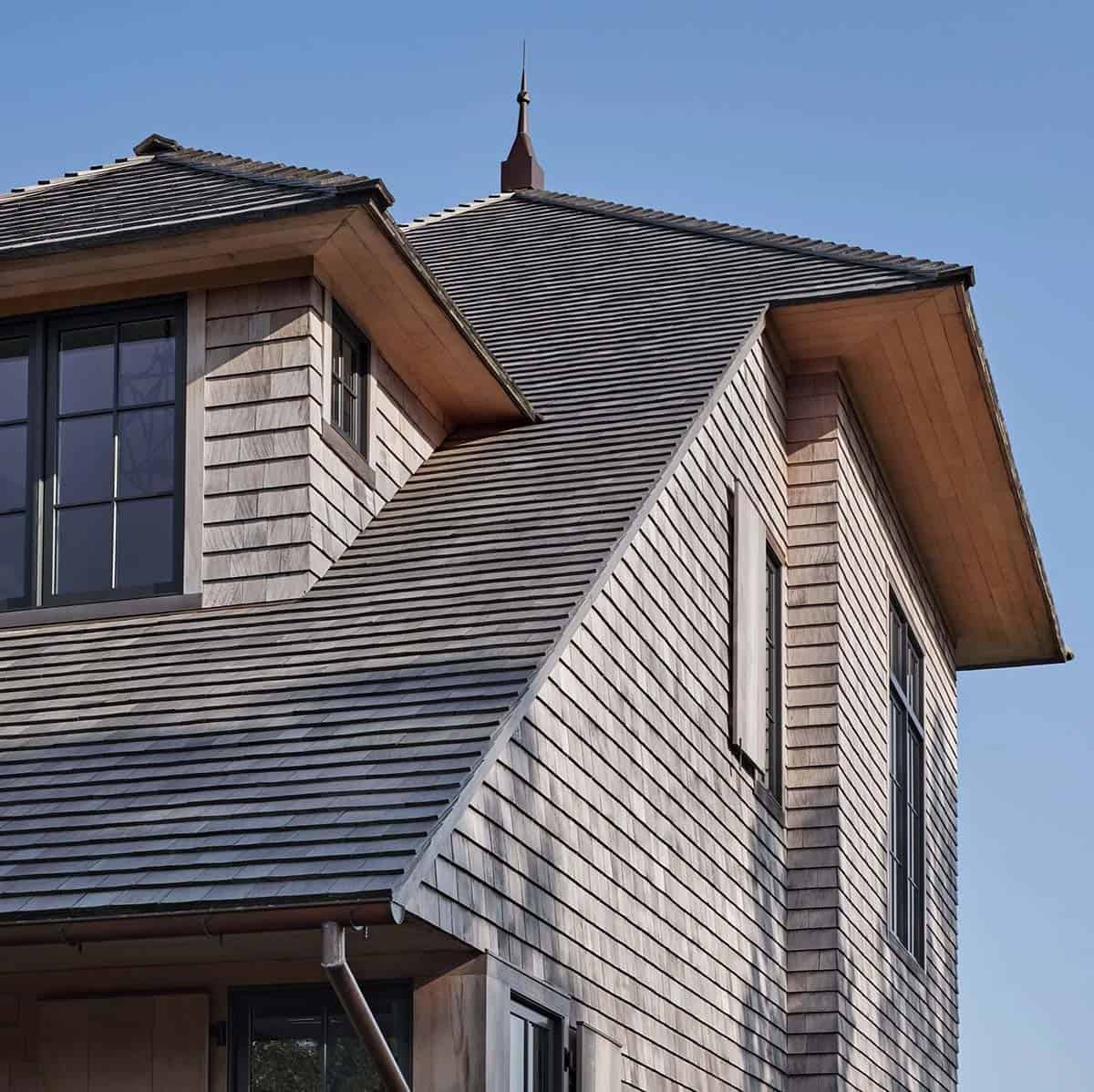 Close-up of cedar shingle and slate roof detail with copper spire and wood soffit