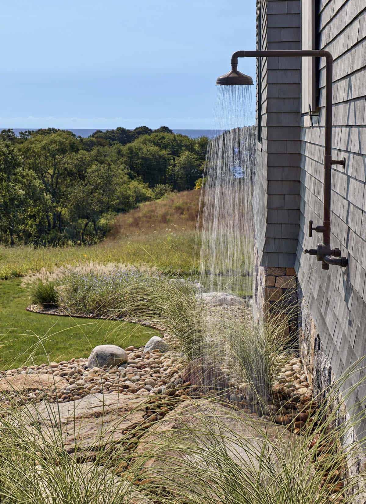 Outdoor shower with a cedar shingle wall and ocean view beyond