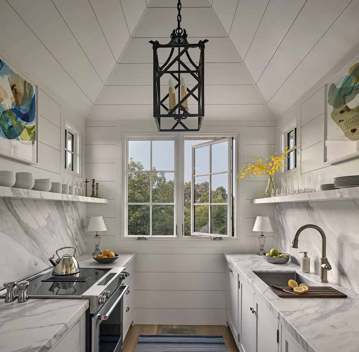 Galley kitchen with shiplap vaulted ceiling, marble countertops, open shelving, and iron lantern pendant