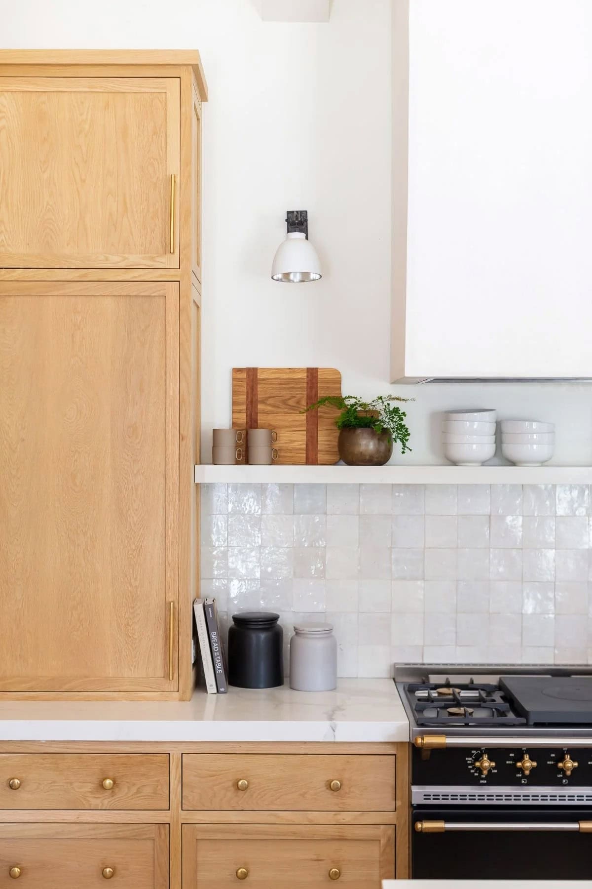 kitchen, white oak cabinetry, zellige tile backsplash, open shelf, black range, brass hardware, wall sconce