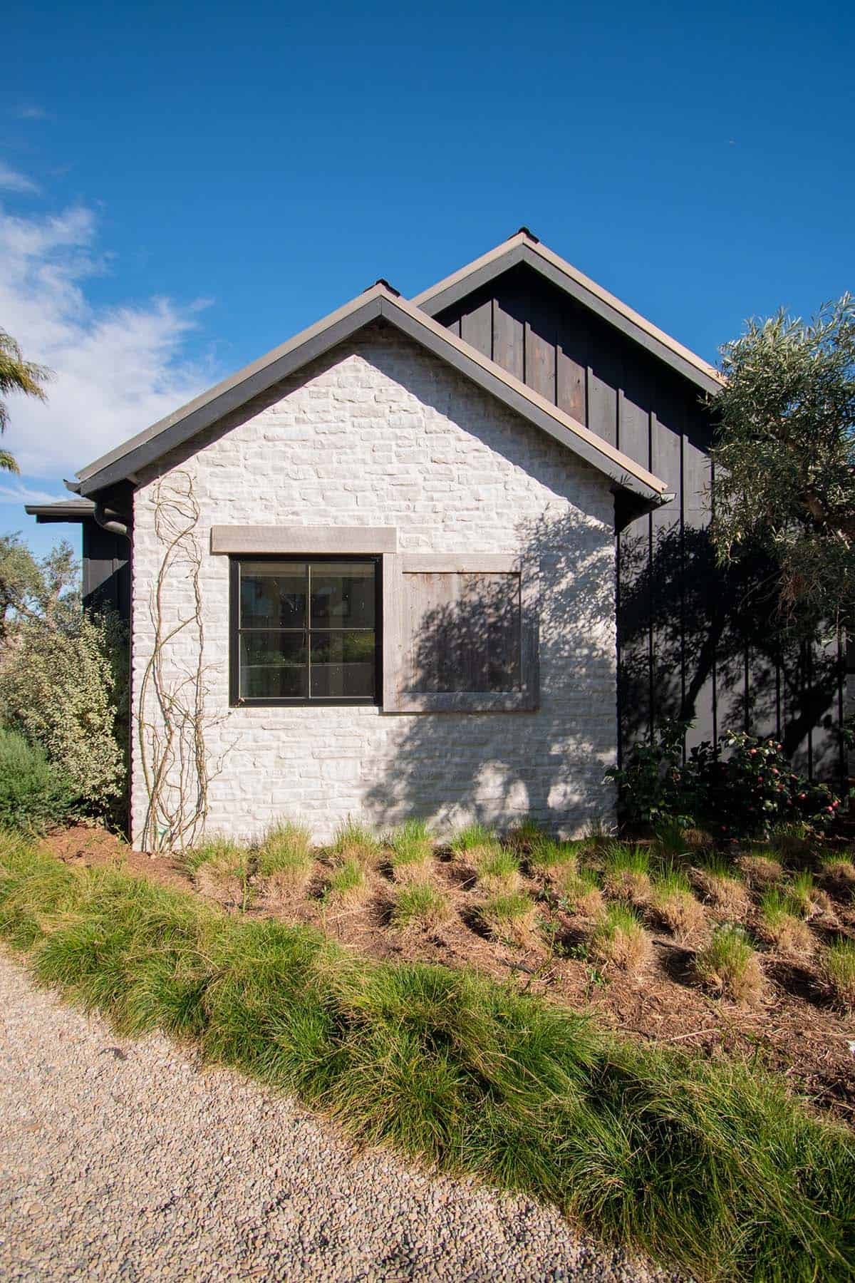 exterior, white painted brick, dark wood siding, black-framed windows, drought-tolerant landscaping