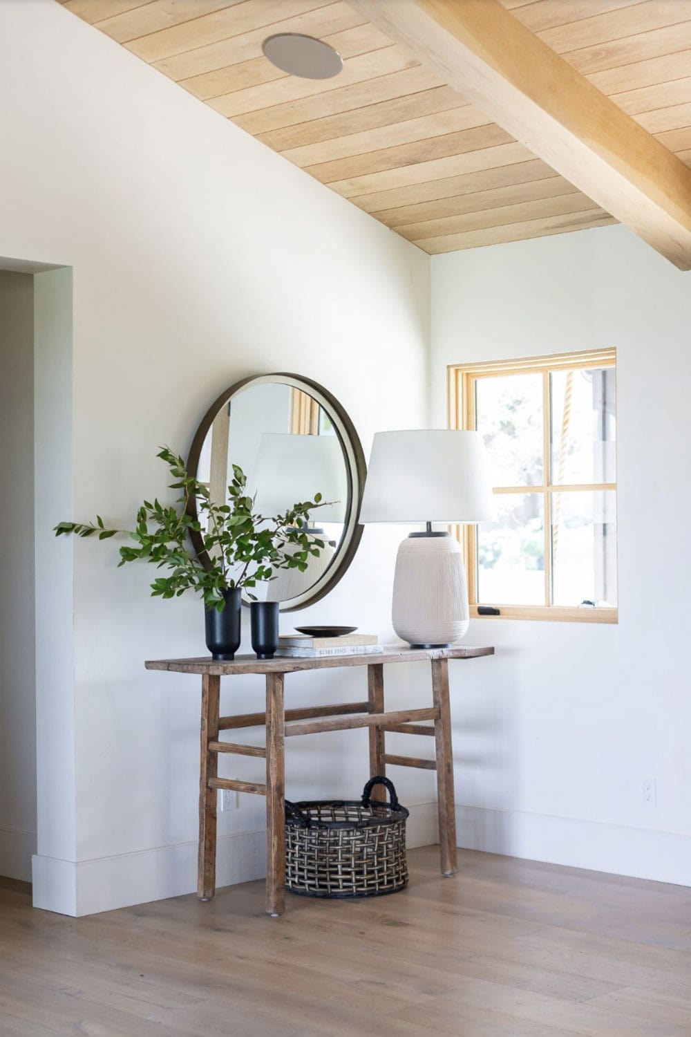 contemporary coastal style home entry with a console table and round mirror