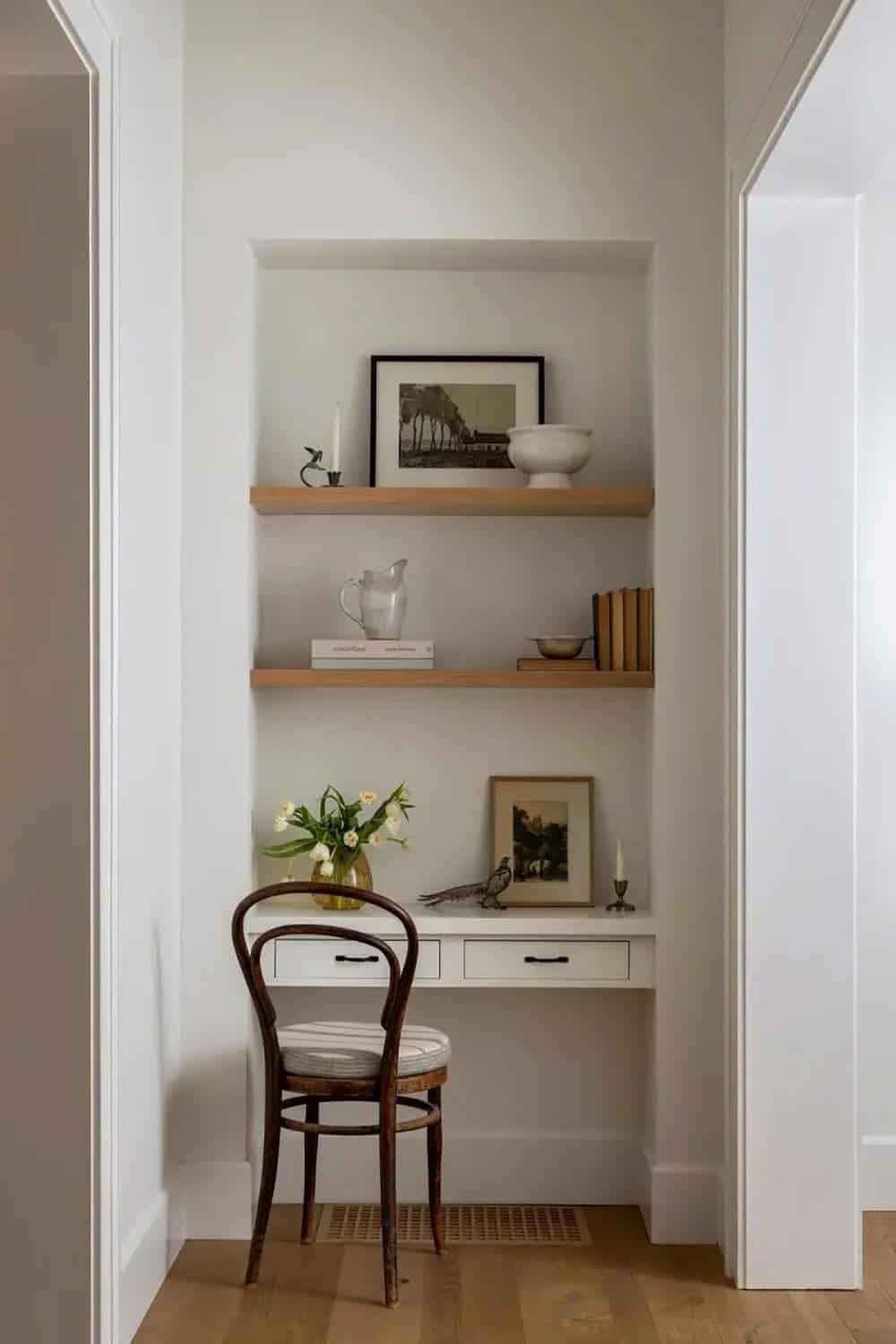Hallway niche with built-in white desk, oak floating shelves, bentwood chair, and tulip arrangement