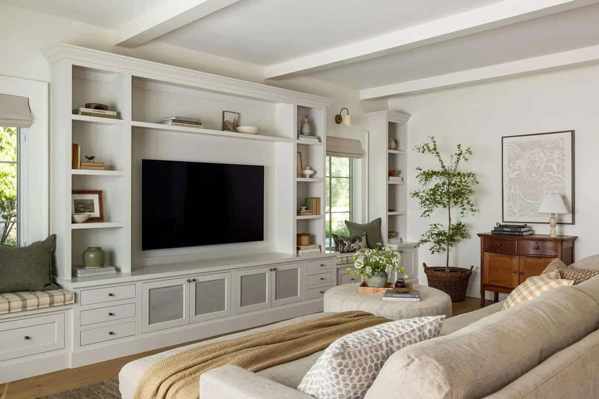 Living room with large built-in entertainment wall, window seat, and exposed ceiling beams