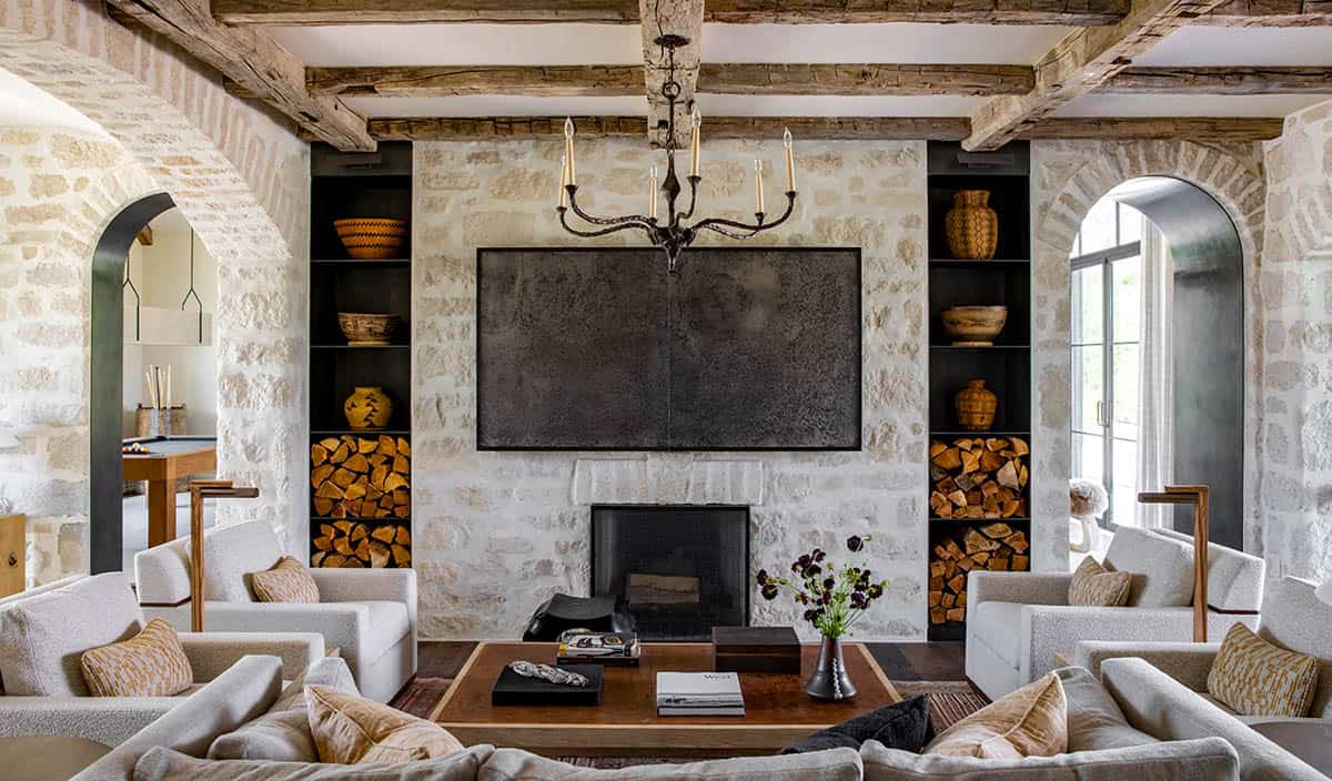 Stone-walled family room with fireplace, built-in wood storage, and Native American pottery