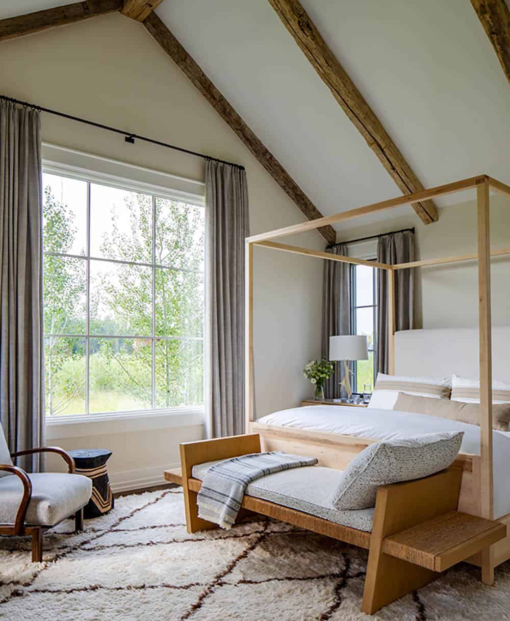 Vaulted guest bedroom with light oak four-poster bed, Beni Ourain rug, and aspen tree views