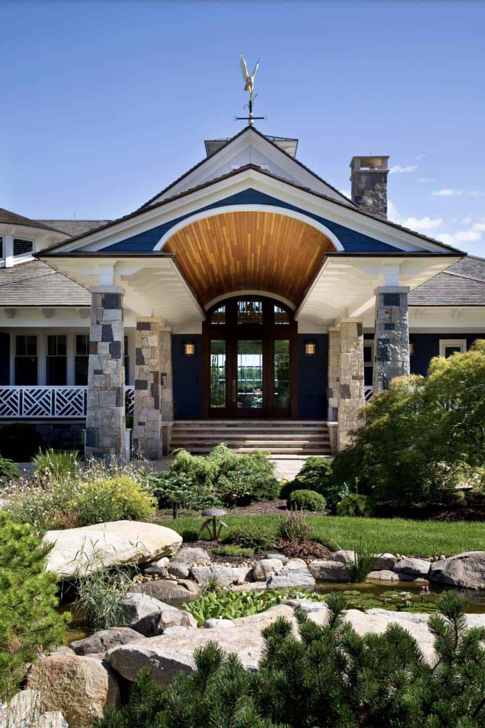 Grand Entry Portico With Stone Columns, Wood Barrel Ceiling, and Arched Wood Door