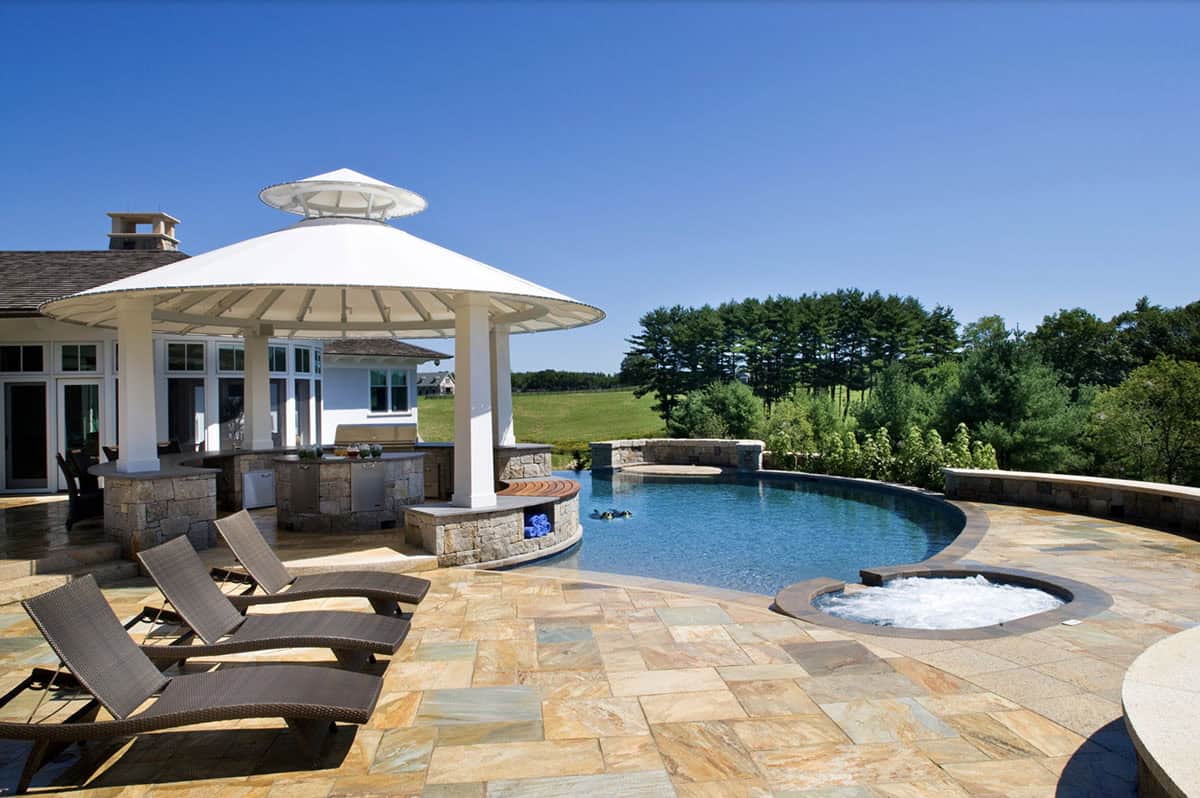 Freeform Pool and Spa With White Gazebo Bar and Stone Patio Overlooking Countryside