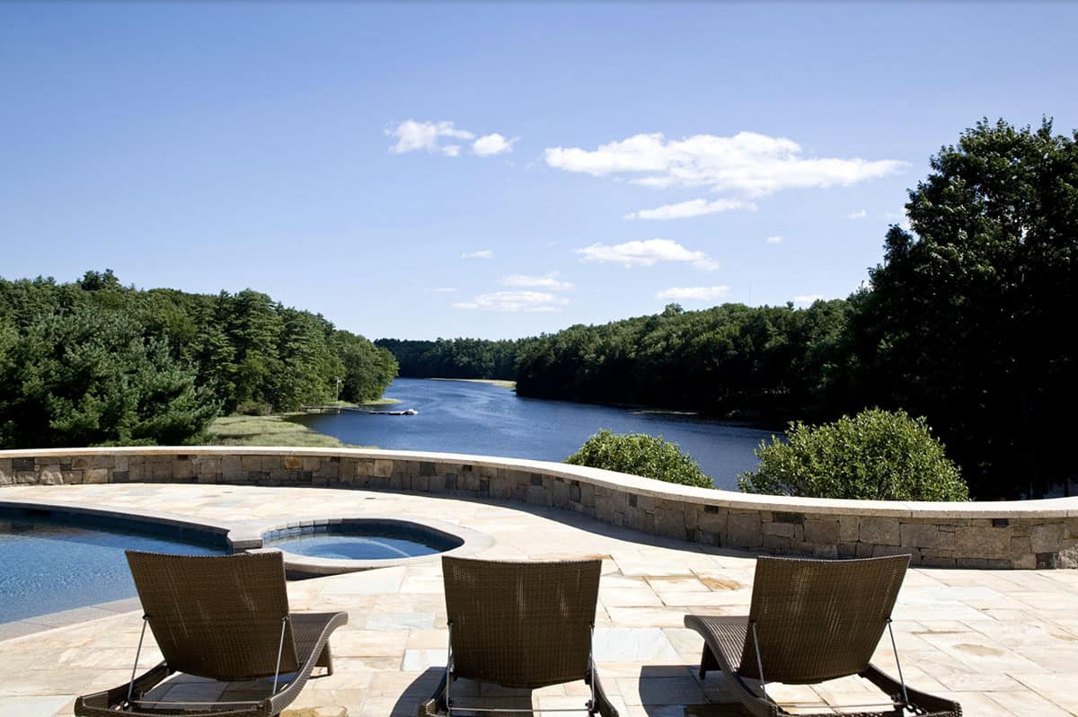 Three Lounge Chairs Facing River Views From Stone-Walled Pool Terrace
