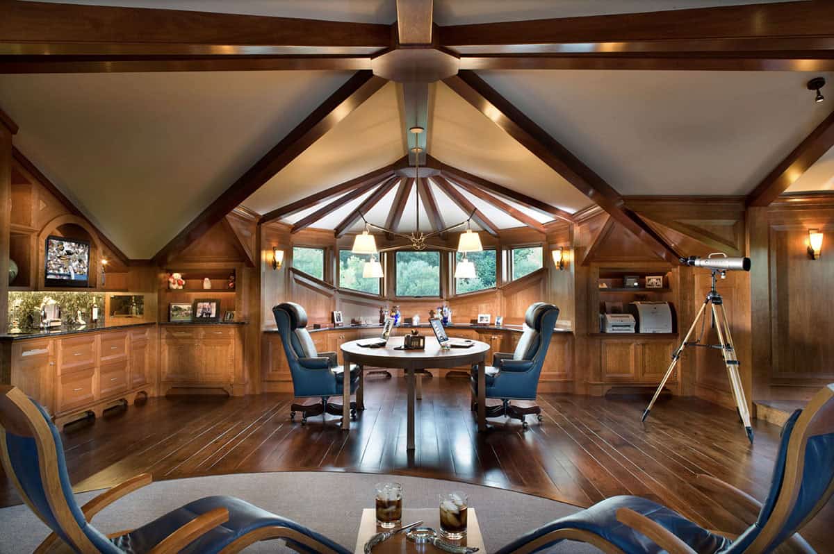 Round Wood-Paneled Home Office With Vaulted Beam Ceiling and Leather Chairs