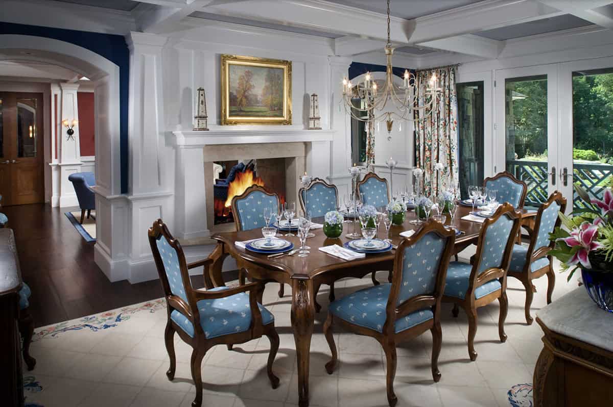 Formal Dining Room With Blue Upholstered Chairs, Stone Fireplace, and Coffered Ceiling