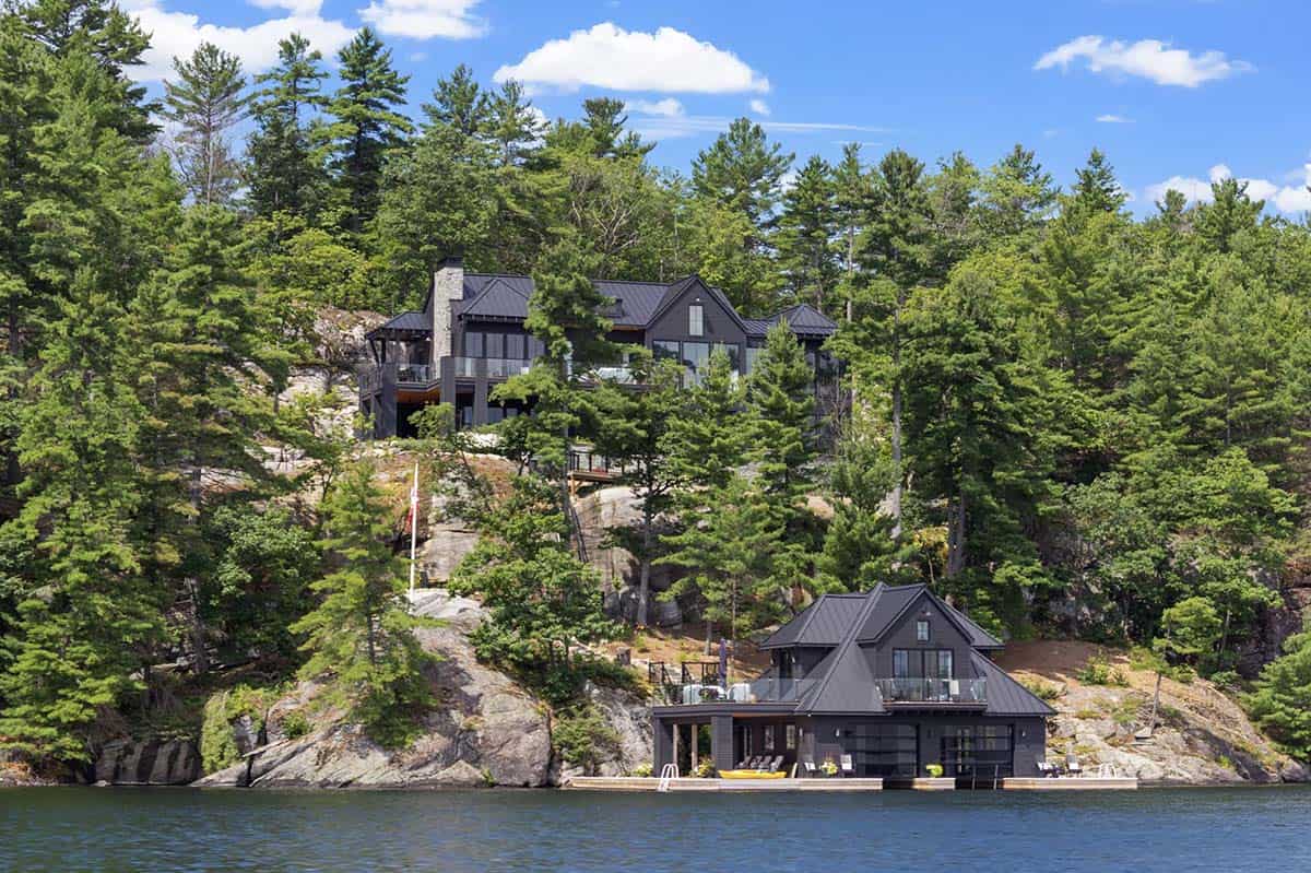 Cottage and boathouse on Lake Joseph, Ontario, Canada, surrounded by pine trees and Canadian Shield rock