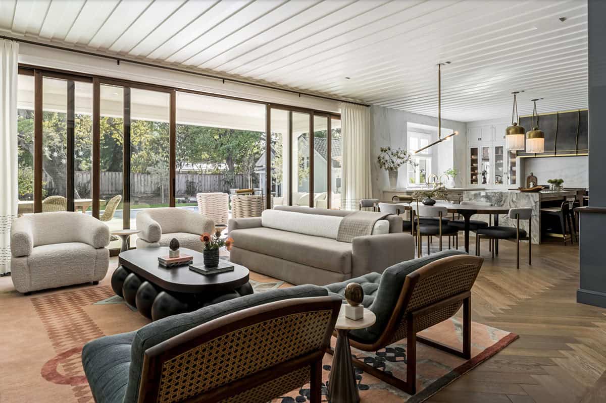 Open-plan family room and kitchen with floor-to-ceiling sliding glass doors opening to backyard