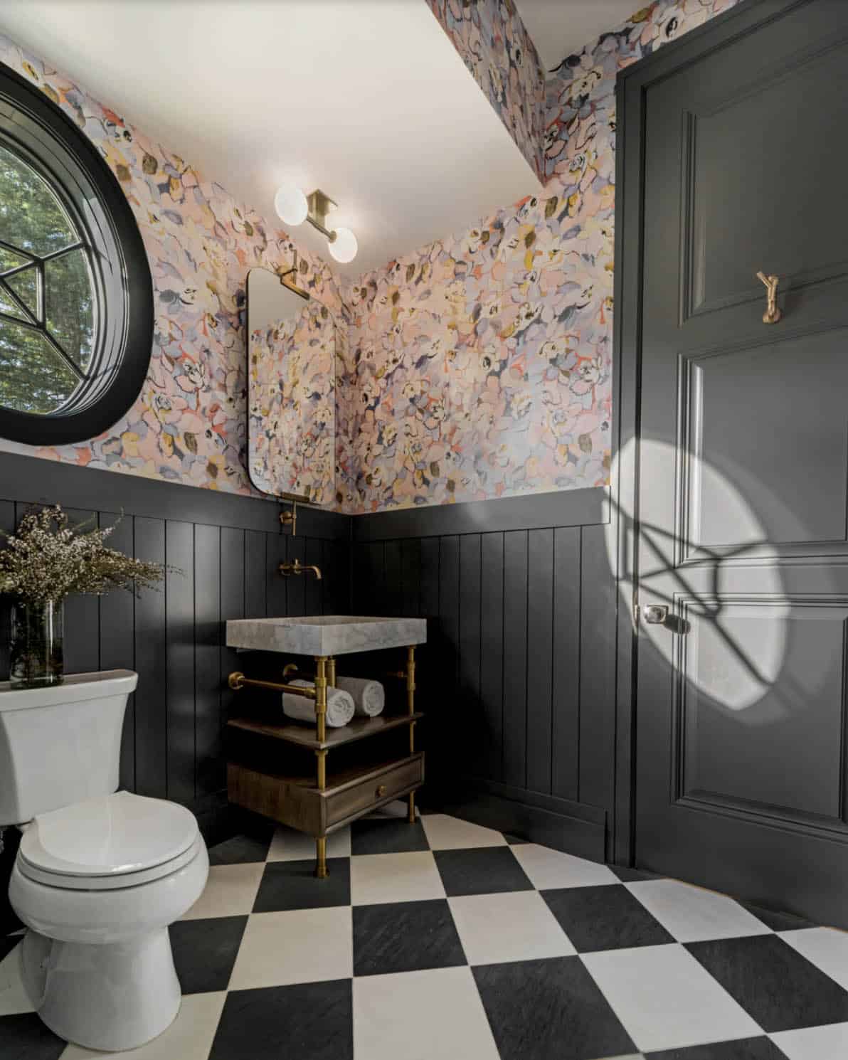 Powder room with bold floral wallpaper, dark beadboard wainscoting, checkered floor, and marble vessel sink
